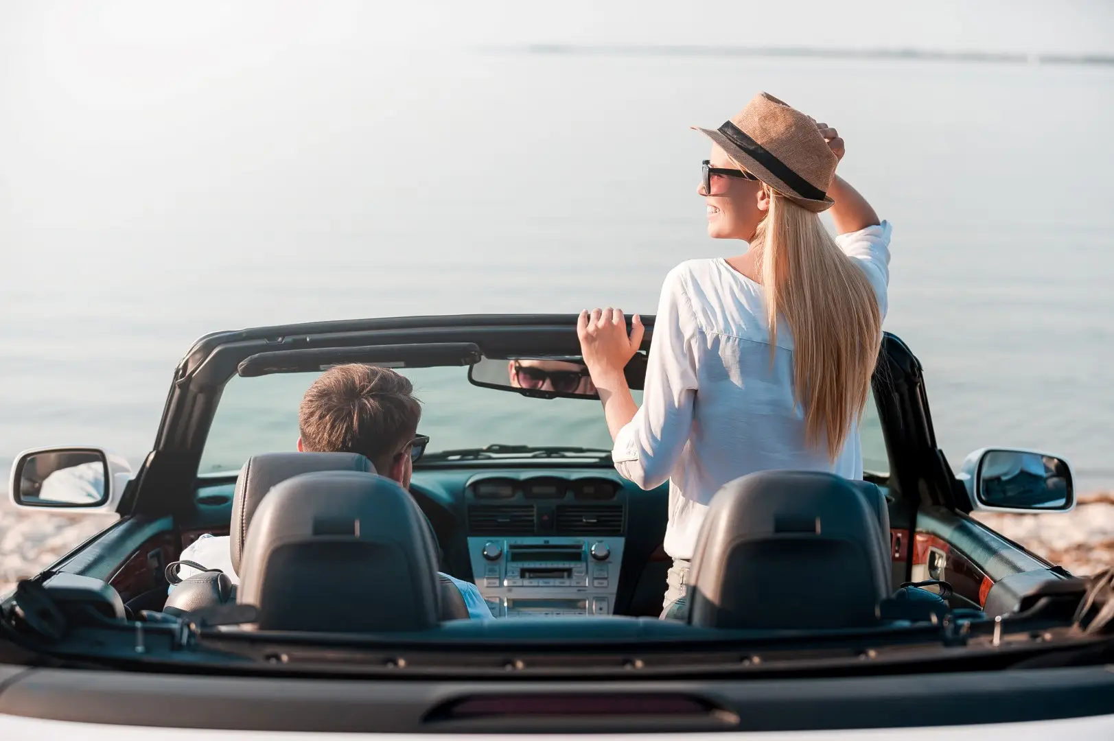 A couple in a convertible looking at the sea